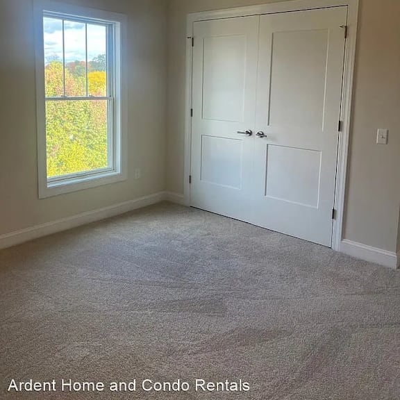 an empty bedroom with a ceiling fan and a window