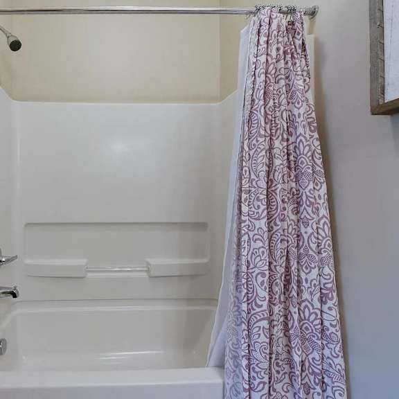 a white bathroom with a shower and a bath tub