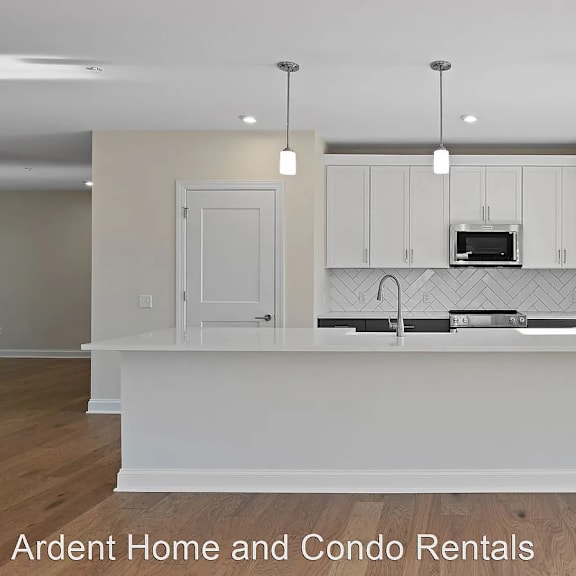 a white kitchen with white cabinets and a large island