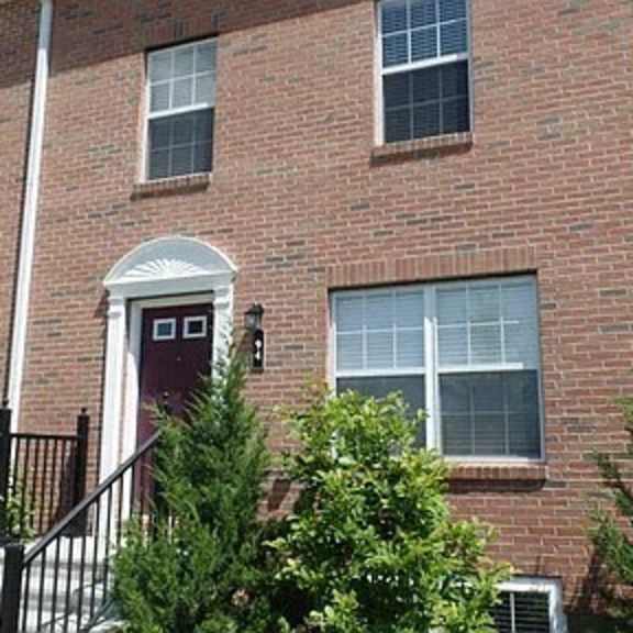 a brick house with a red door and windows