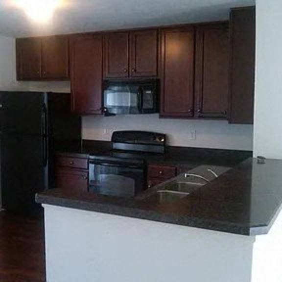 a kitchen with a counter top and a black refrigerator