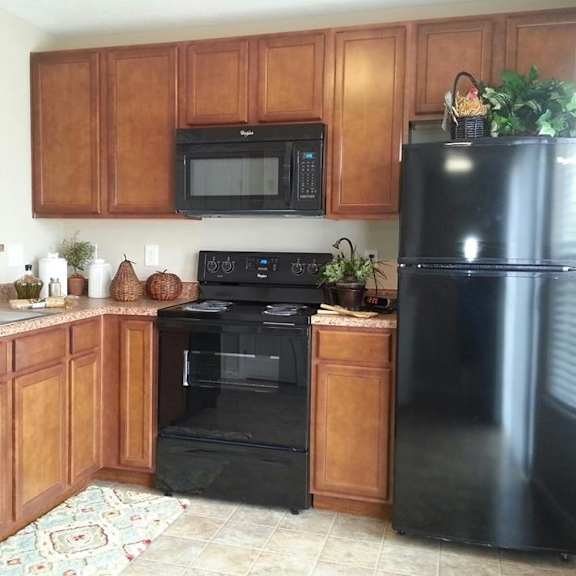 a kitchen with black appliances and wooden cabinets.