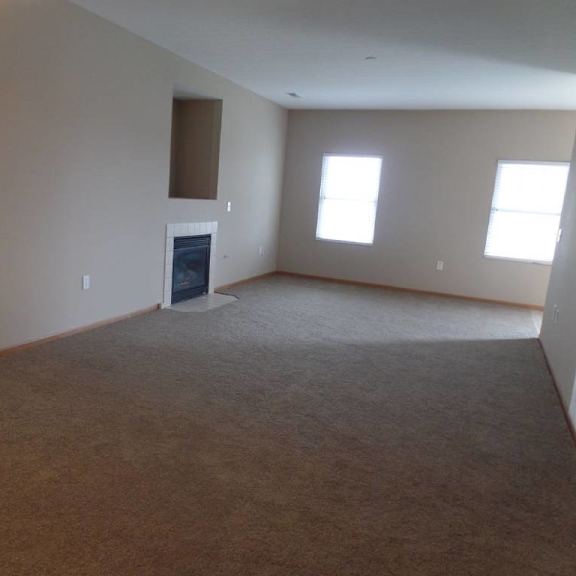 an empty living room with a fireplace
