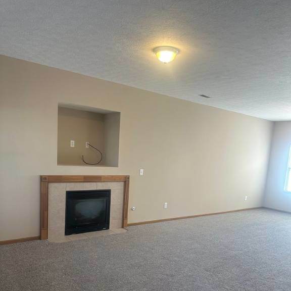 an empty living room with a fireplace