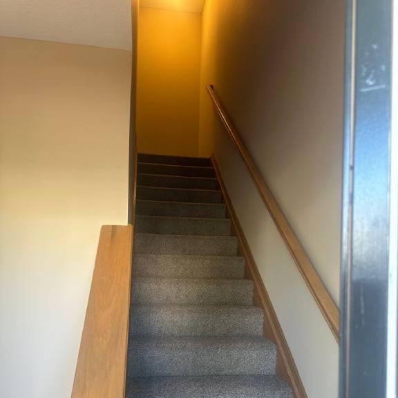 a set of stairs with a wooden railing in a house
