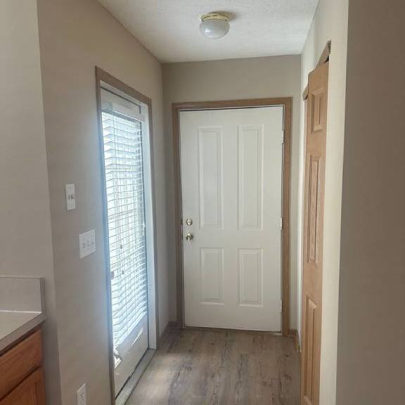 a hallway with a white door and a window