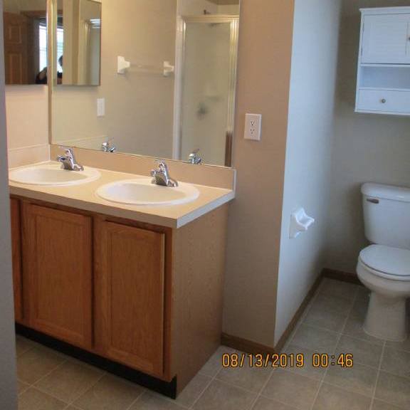 a bathroom with two sinks and a toilet
