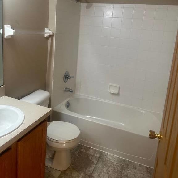 a white bathroom with a toilet and a tub