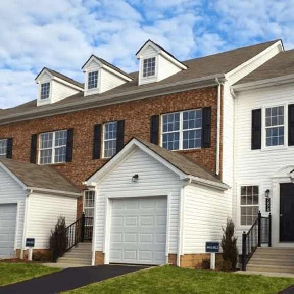 a row of houses with garages in front.