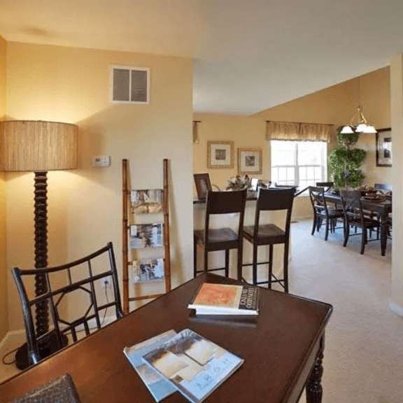 a living room with a brown table and chairs.