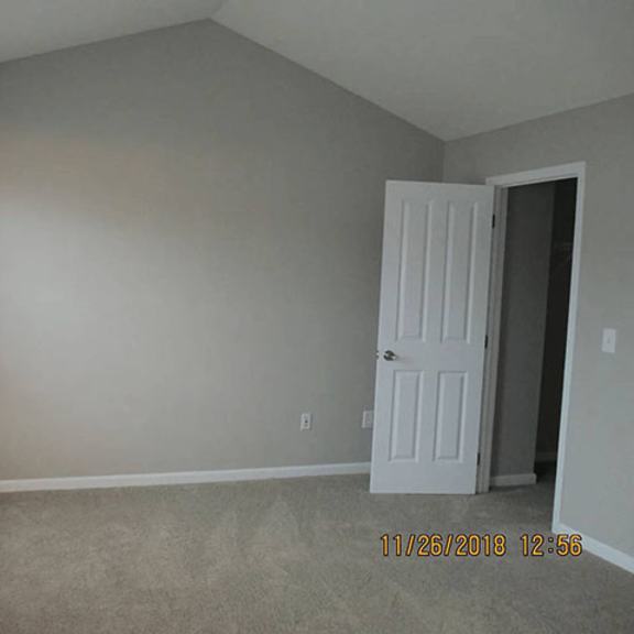 a room with a white door and a window with blinds.