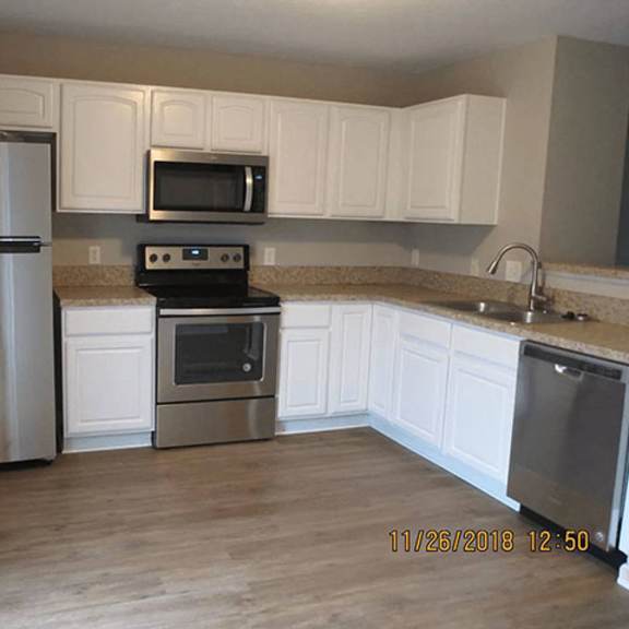a kitchen with a stainless steel refrigerator, microwave, oven, and sink.