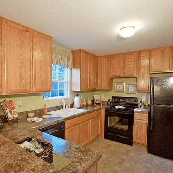 a kitchen with wooden cabinets and a black refrigerator.