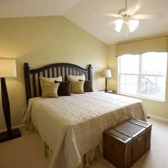 a bedroom with a bed, nightstand, and window.
