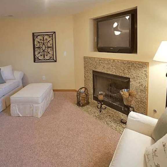 a living room with a fireplace and a television mounted above it.