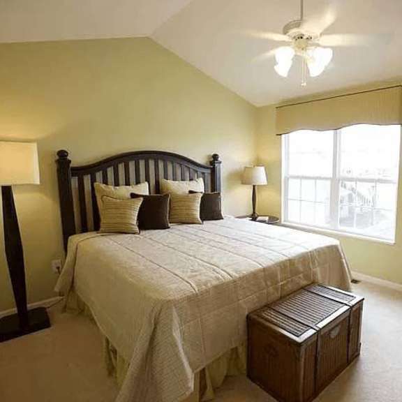 a bedroom with a bed, nightstand, and window.