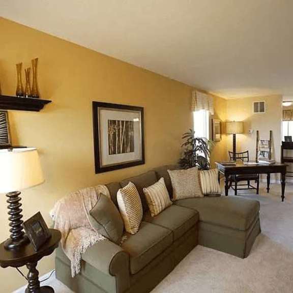 a living room with a couch, a table, and a lamp.