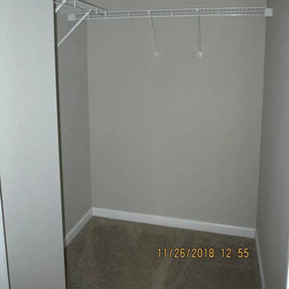 a small, empty closet with a shelf and a date stamp on the floor.
