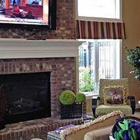 a living room with a fireplace and a painting of a horse on the wall.