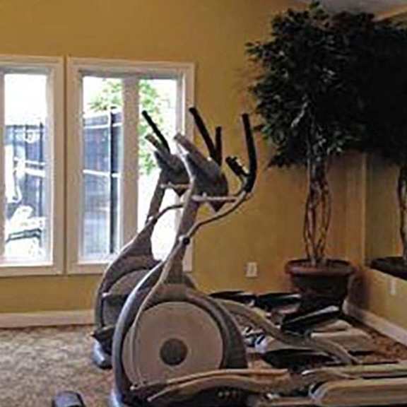 a room with exercise equipment and a mirror.