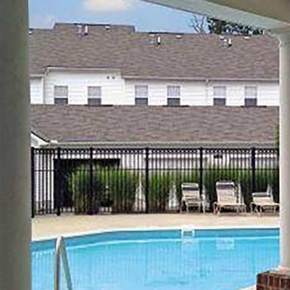 a pool with a white house in the background.