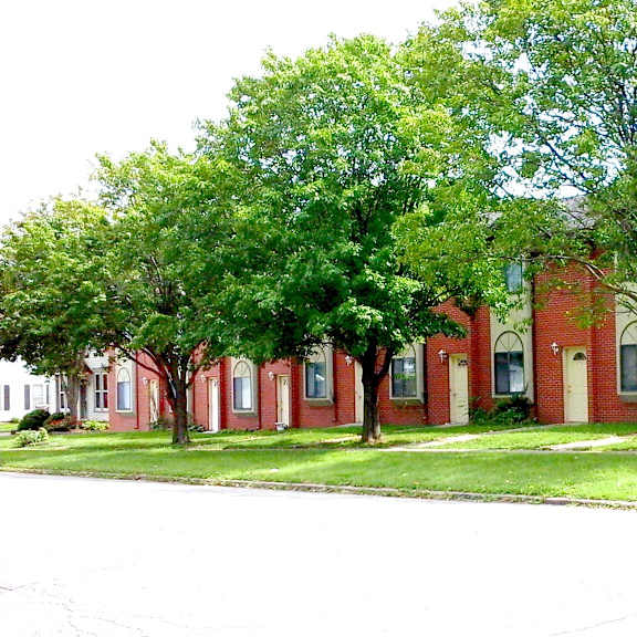 a brick building with trees in front of it