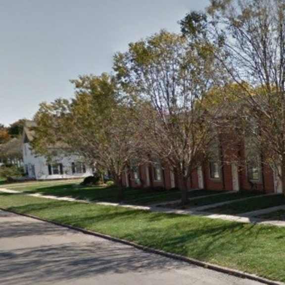 a row of brick apartment buildings on the side of a street