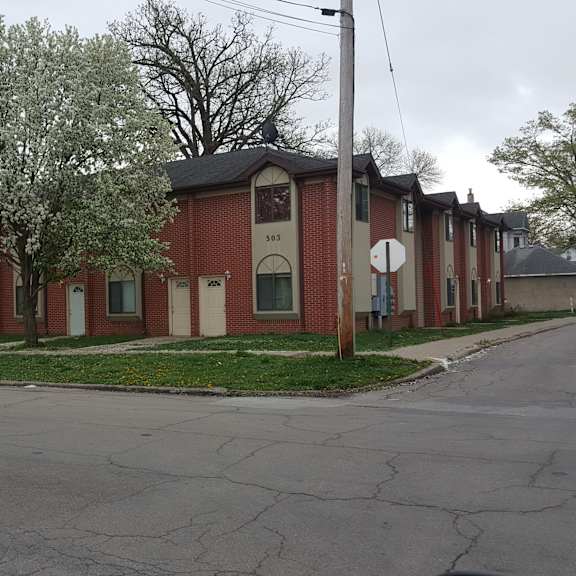 a red brick building on a street corner with trees