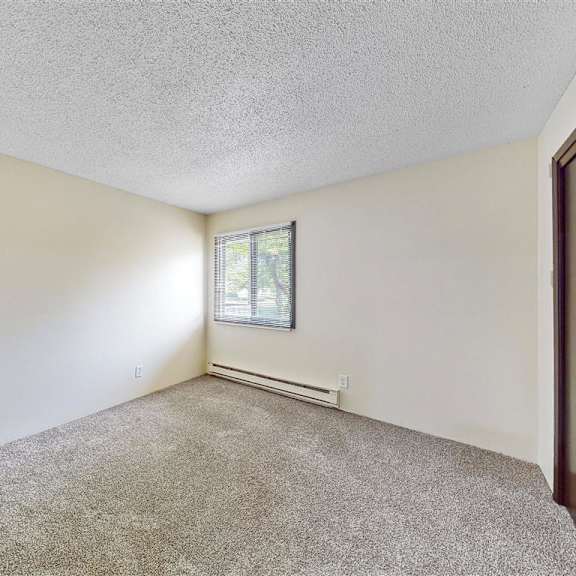 the living room of a home with carpet and a window