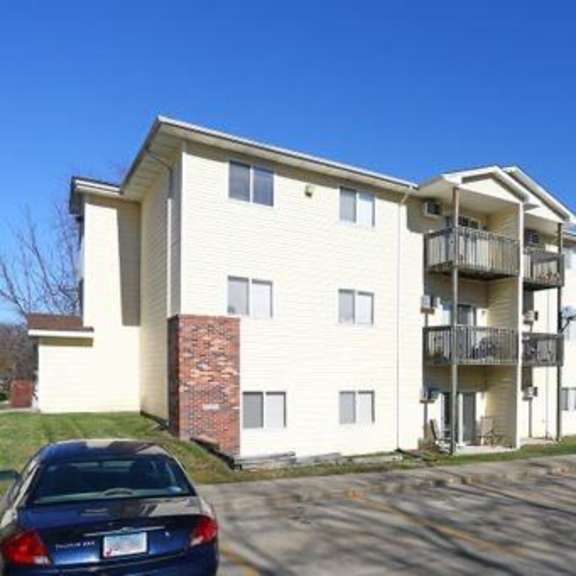 an apartment building with cars parked in front of it