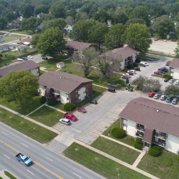 an aerial view of a neighborhood of houses with cars parked on the street