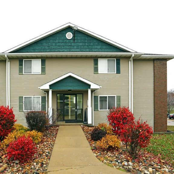 a brown house with a sidewalk in front of it