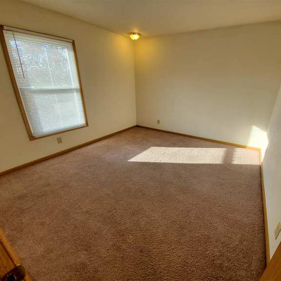 a room with a carpeted floor and a window