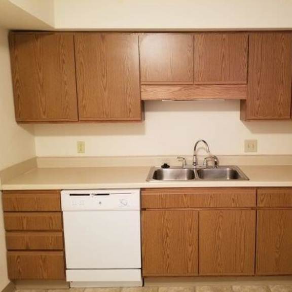 a kitchen with white appliances and wooden cabinets