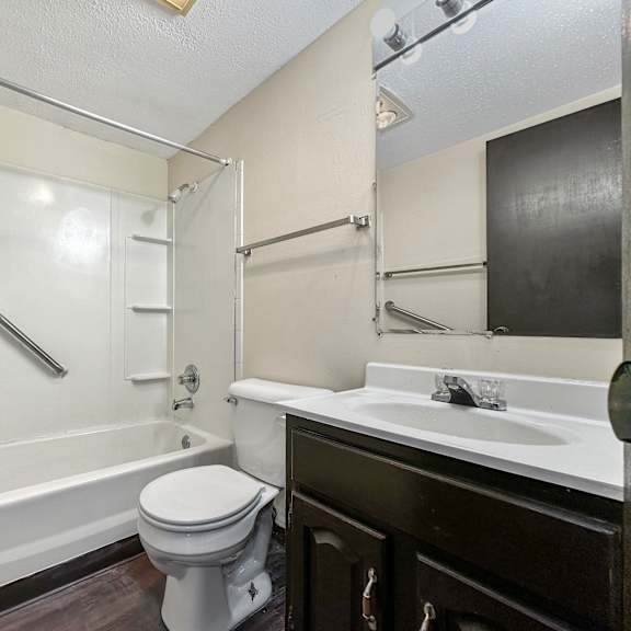 a white toilet sits next to a bathtub in a bathroom.