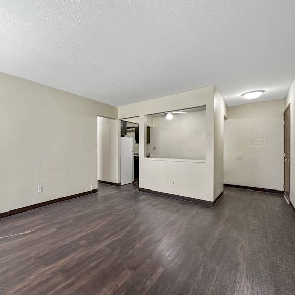 a room with wood flooring and white walls.