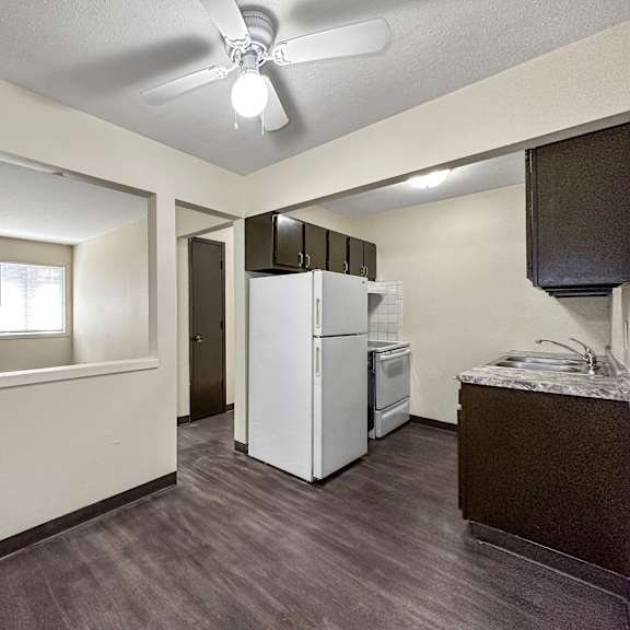 a kitchen area with a refrigerator, microwave, and oven.