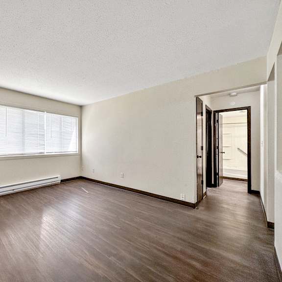 a room with a brown floor and white walls.