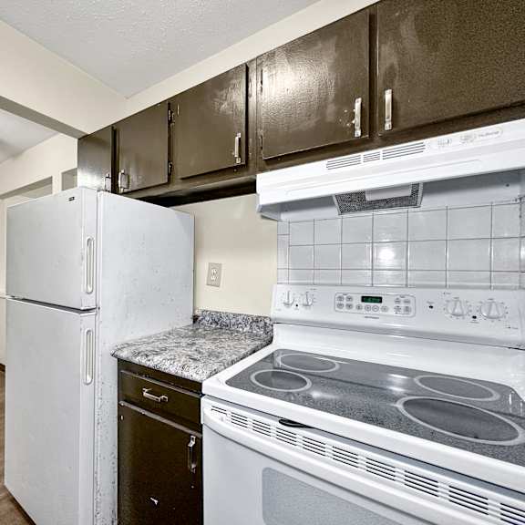 a kitchen with a white fridge and stove.