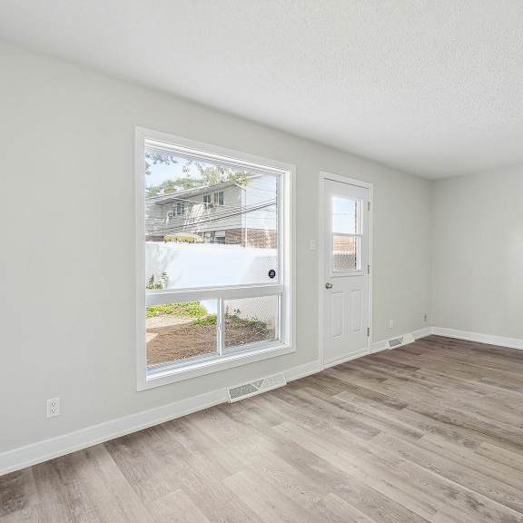 a room with a window and wooden flooring.