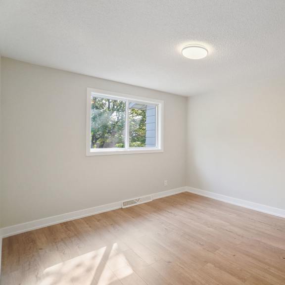 a room with a window and wooden flooring.