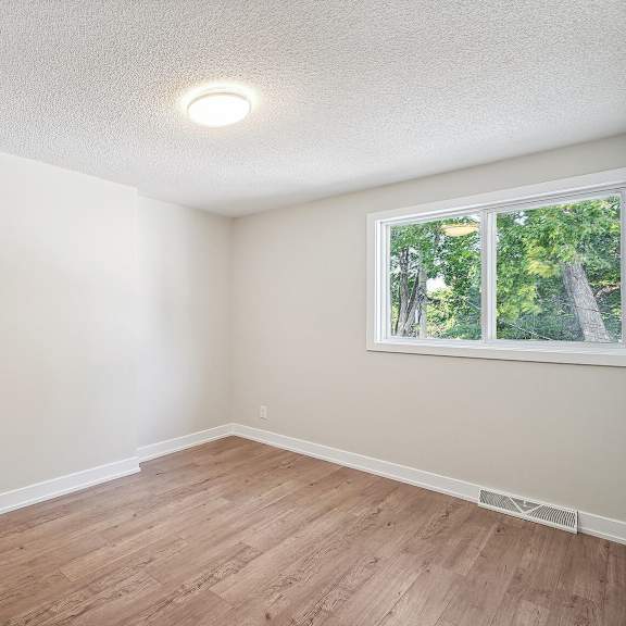a room with a window and wooden flooring.