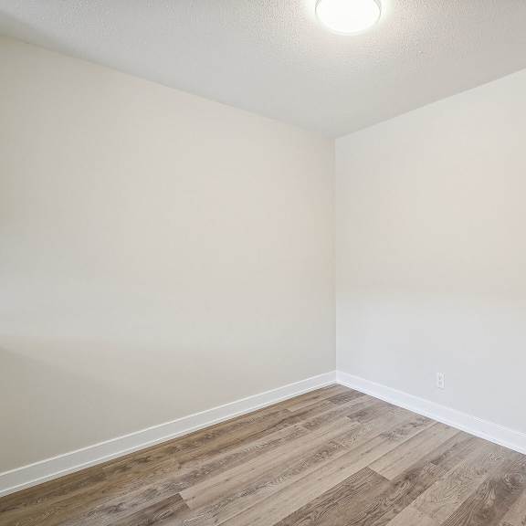 a room with wooden flooring and white walls.