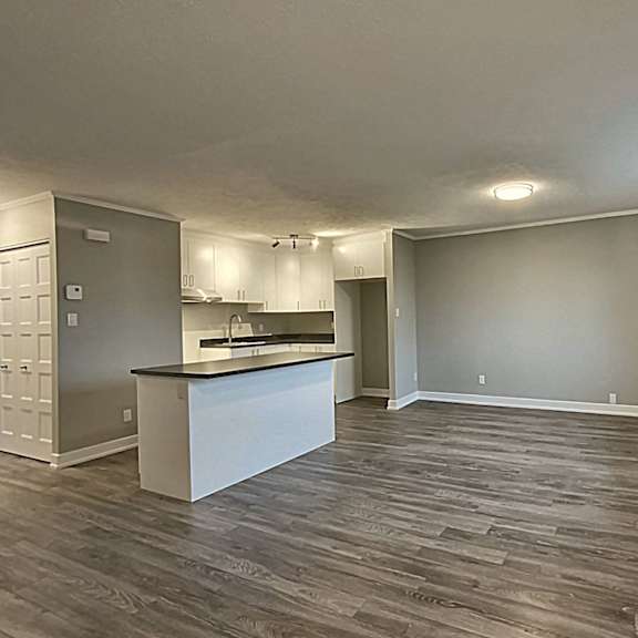 a kitchen with a white island and wooden floors.