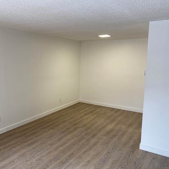a room with wooden flooring and white walls.