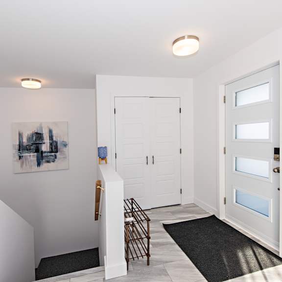 a white door with a black mat in front of it.