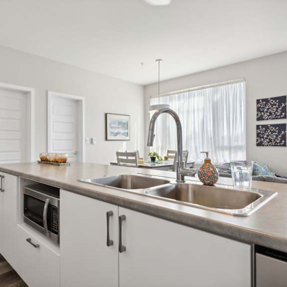 a modern kitchen with a stainless steel sink and a microwave oven.
