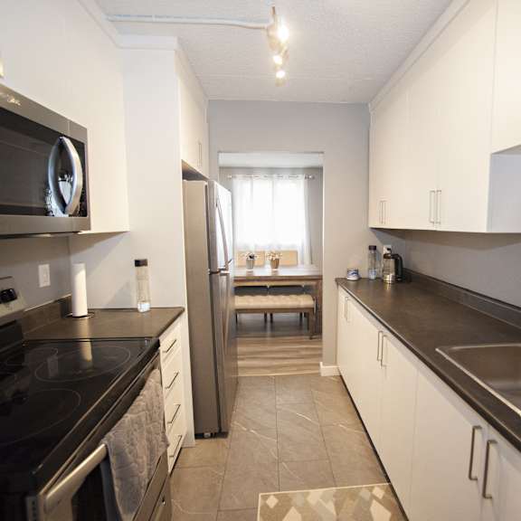 a kitchen with black countertops and stainless steel appliances.