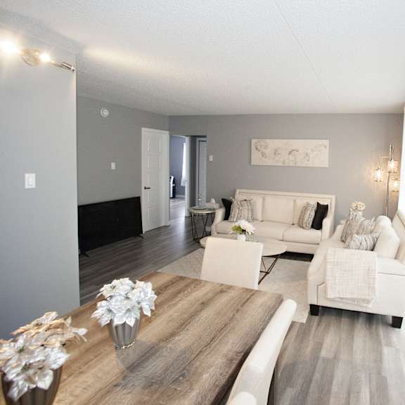 a living room with a white couch and a wooden table.