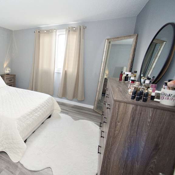 a bedroom with a large bed and a vanity with a mirror.